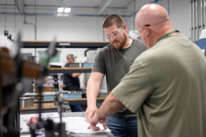 Engineers reviewing part specs on production floor