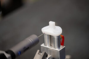 Machined plastic component fixtured in inspection station