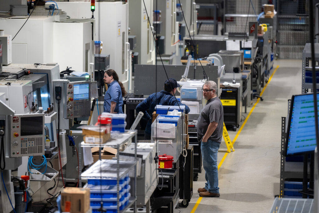 Wide-angle view of CNC machines and operators on shop floor