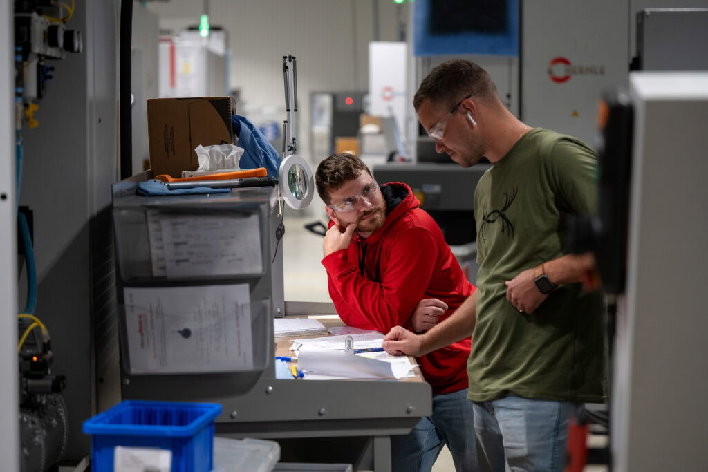 Engineering team reviewing plans and inspecting prototype